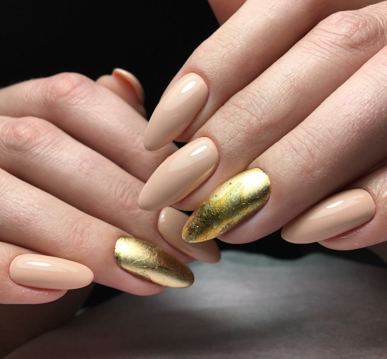 Unghie gel a mandorla, colore beige e un accent nail sul dito anulare smalto color oro 